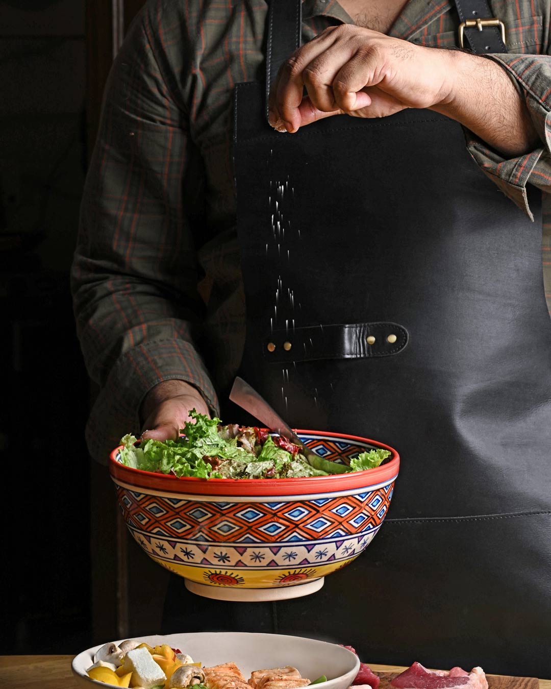 Sprinkling smoked sea salt on a bowl of Salad at BraaiCraft Smokehouse Gurgaon